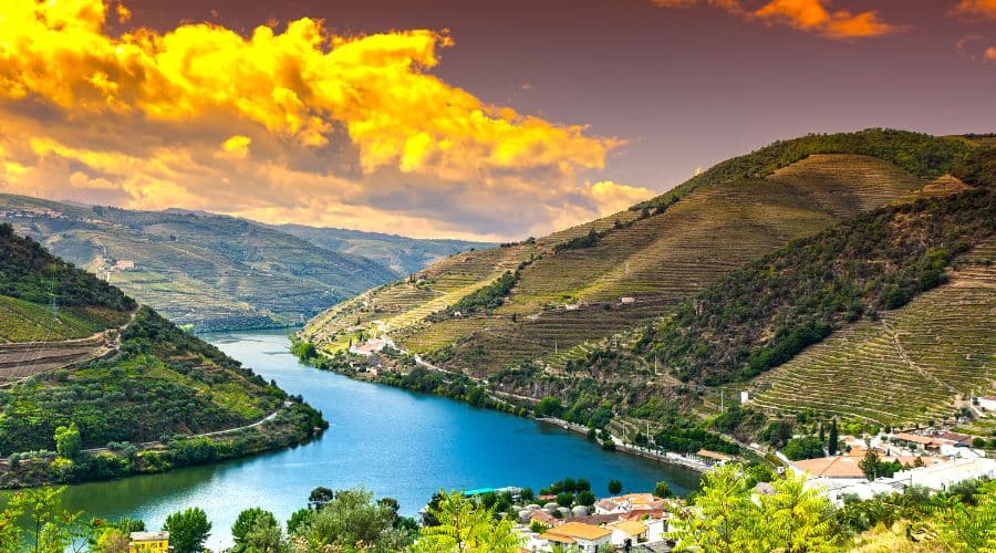 Região do Douro em Portugal. Rio Douro em forma de S, contornando as montanhas que ficam as uvas que são plantadas pelas vinícolas e no horizonte o pôr do sol