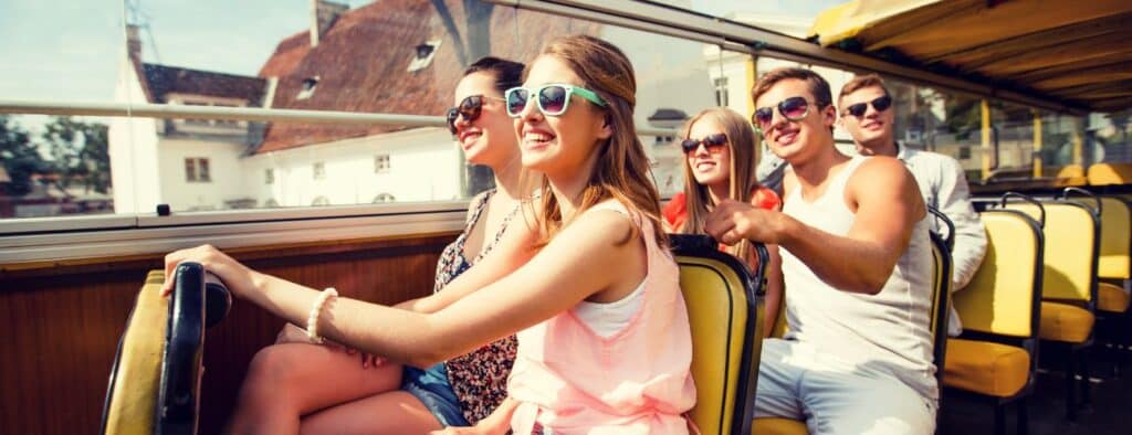 Turistas em um ônibus felizes que estão conhecendo a cidade através de um City Tour da Civitatis
