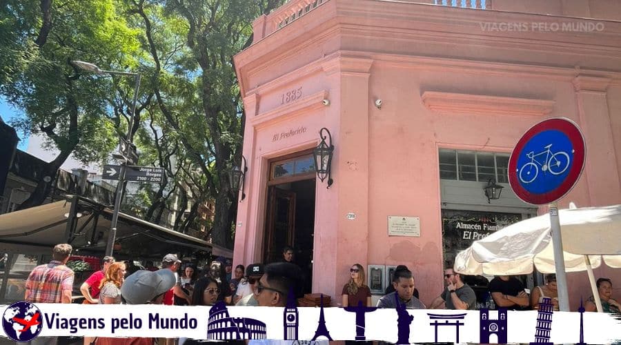 Entrada do El Preferido em Buenos Aires. Restaurante com cor rosa e com vários turistas aguardando na fila para entrar.