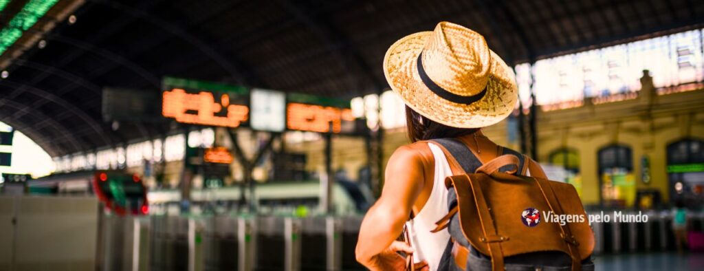 Mulher na estação de trem na Europa usando o celular com chip internacional para encontrar sua passagem.