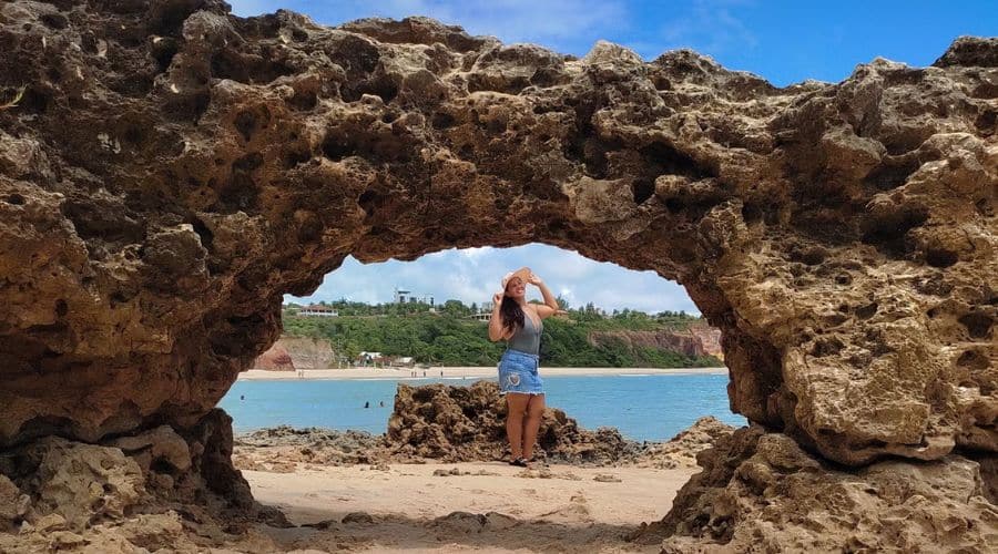 Praia do Amor: Mulher ao fundo e na frente uma pedra natural em formato de coração