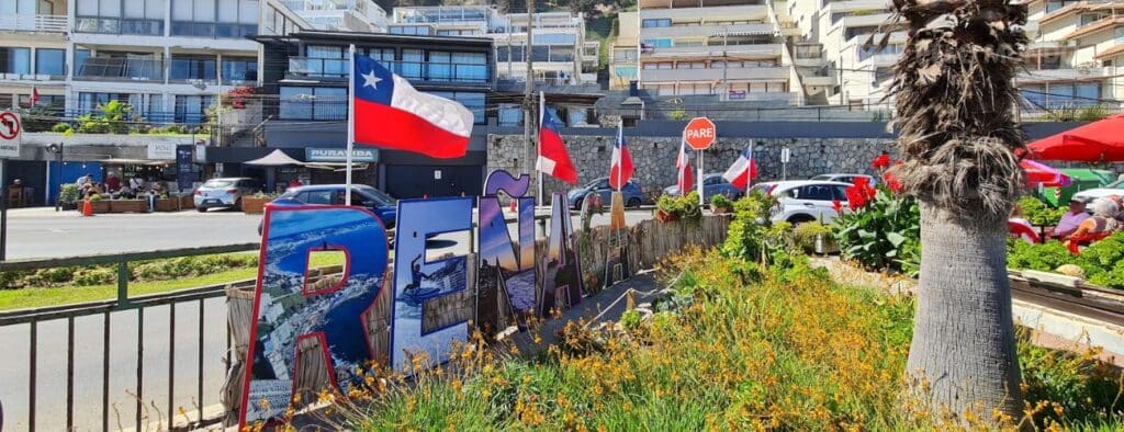 Como ir de Santiago para Valparaiso. Placa de Reñaca em Viña del Mar com bandeiras do Chile ao fundo.