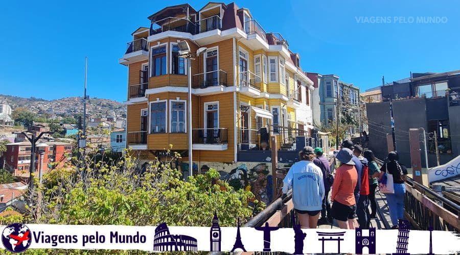 Conhecendo Valparaíso. Casarão histórico em Valparaíso com turistas caminhando na plataforma com o guia turístico.