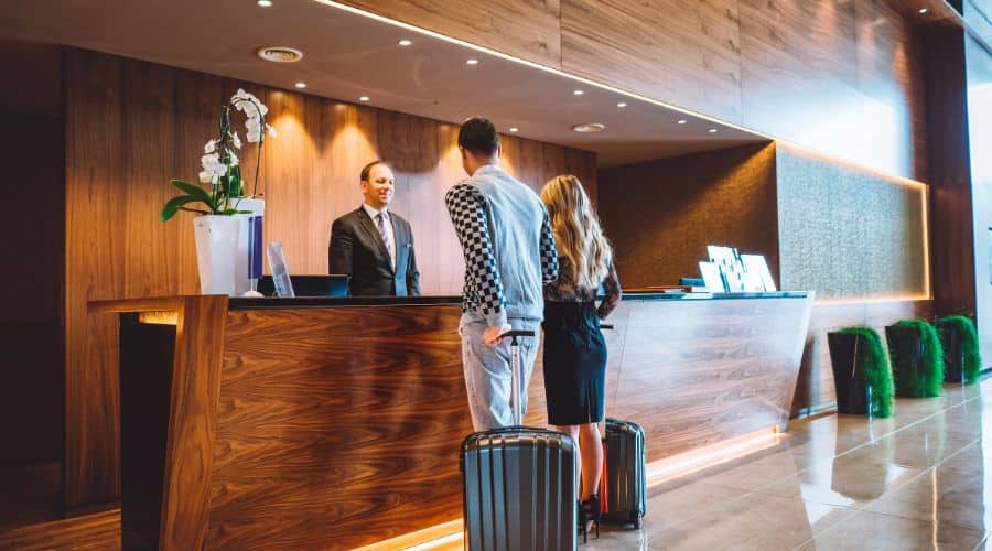 Casal com duas malas fazendo o check-in em um hotel em Buenos Aires