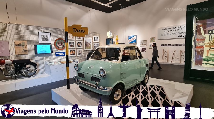 Exposição com um mini carro antigo com outros objetos antigos