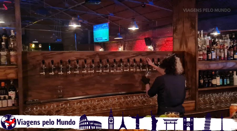 Mulher servido uma cerveja artesanal com diversas torneiras