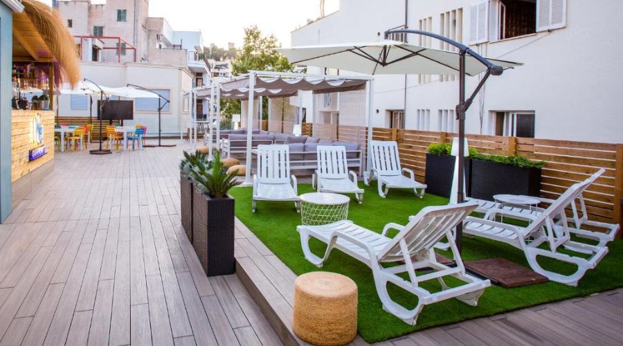 Terraço com piso de madeira e cadeiras de sol e sofás