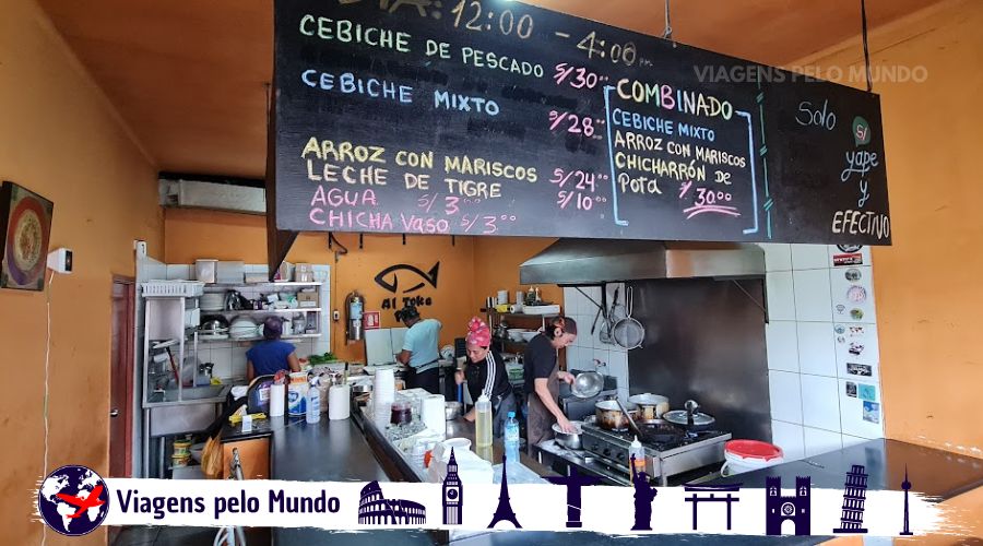 Restaurante pequeno com uma pequena cozinha e as mesas em volta