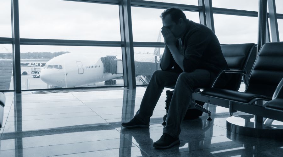 Pessoa triste sentado no aeroporto.