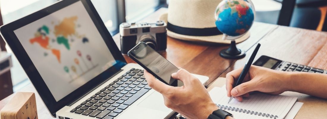 Notebook aberto com um site para descobrir onde comprar um pacote de viagem